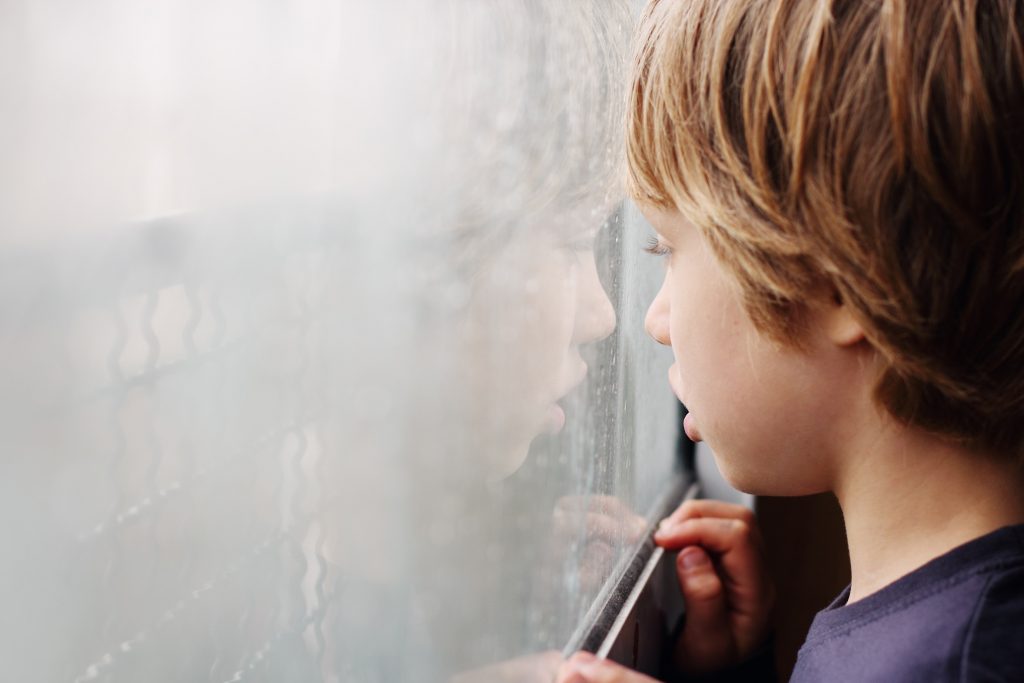 Niño con autismo en la ventana
