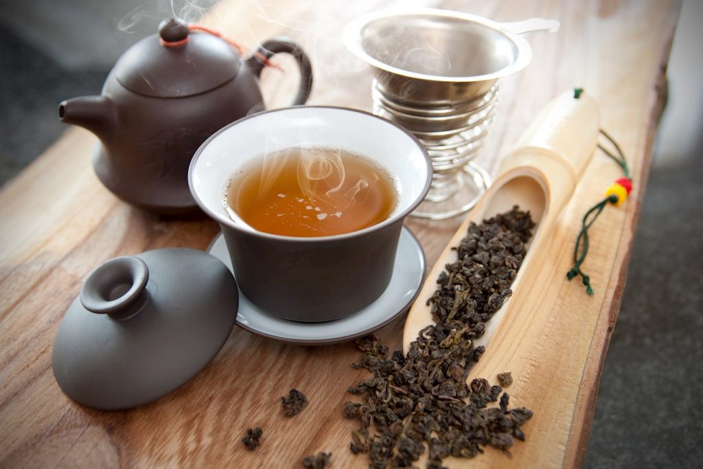 Taza y hojas de té Oolong con muchas propiedades saludables
