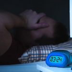 Persona sufriendo de insomnio en la madrugada