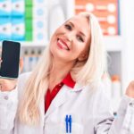 mujer de la farmacia con un celular en la mano