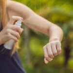 mujer colocandose repelente para mosquitos